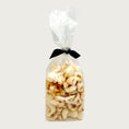 Load image into Gallery viewer, 2 oz clear cellophane bag of Wet Nose exclusive Moo Rinds dog treats, tied with black ribbon. Treats inside are ivory colored, and look like thick, curled chips.