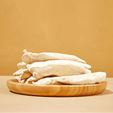 A wooden plate full of Freeze-Dried Chicken Breast tenders from Arya! Sit. Side view of tenders stacked high. 4"-5" long tenders are whole, not in pieces.