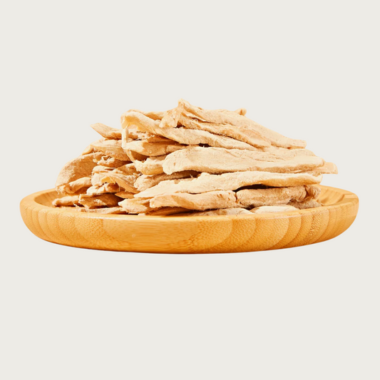 A wooden plate full of Freeze-Dried Duck Breast tenders from Arya! Sit. Side view of tenders stacked high. 4"-5" long tenders are whole, not in pieces.