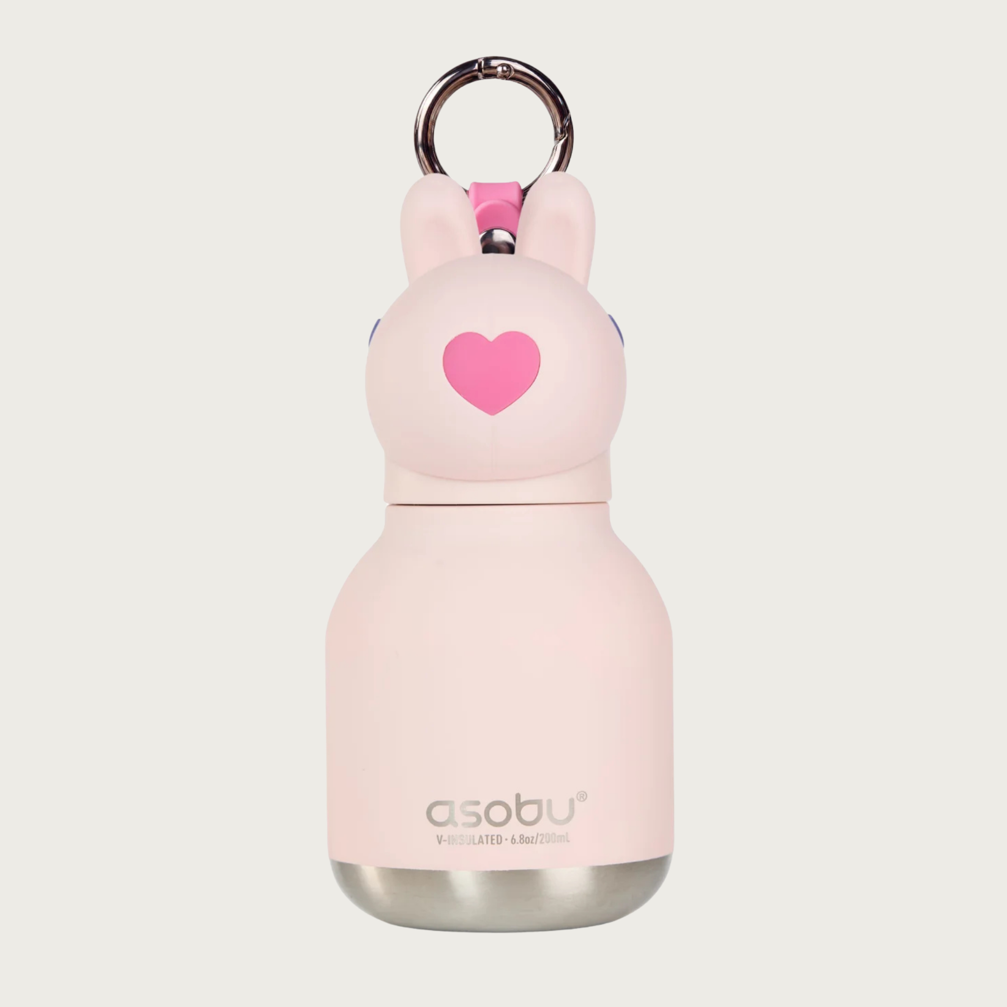 A light pink insulated water bottle with a rabbit-shaped cap, featuring a hot pink heart-shaped nose and pale pink long ears, a silver metal key ring, and the 'asobu' brand name printed near the bottom on the silver metal toned base.