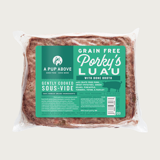 A shrink-wrapped, clear plastic pouch containing frozen, gently cooked Porky's Luau recipe dog food from A Pup Above. Green label provides product details.