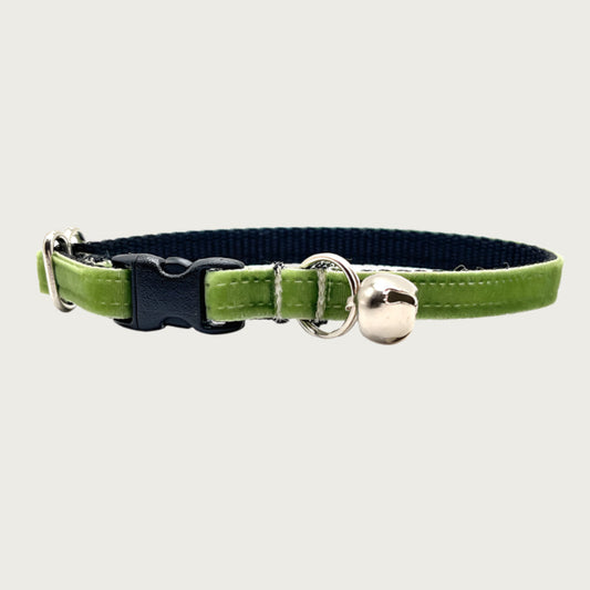 Moss green hued velvet cat collar with a silver bell and small D-ring. Black nylon inner webbing and black plastic buckle.