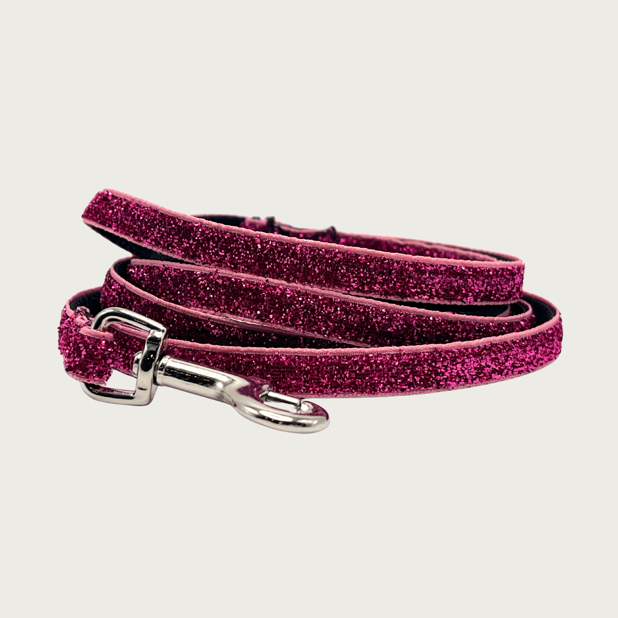Skinny, rosy pink hued glitter dog leash with black nylon inner webbing and silver metal clasp. The fabric itself is shimmery & glittery - it is not glued on.