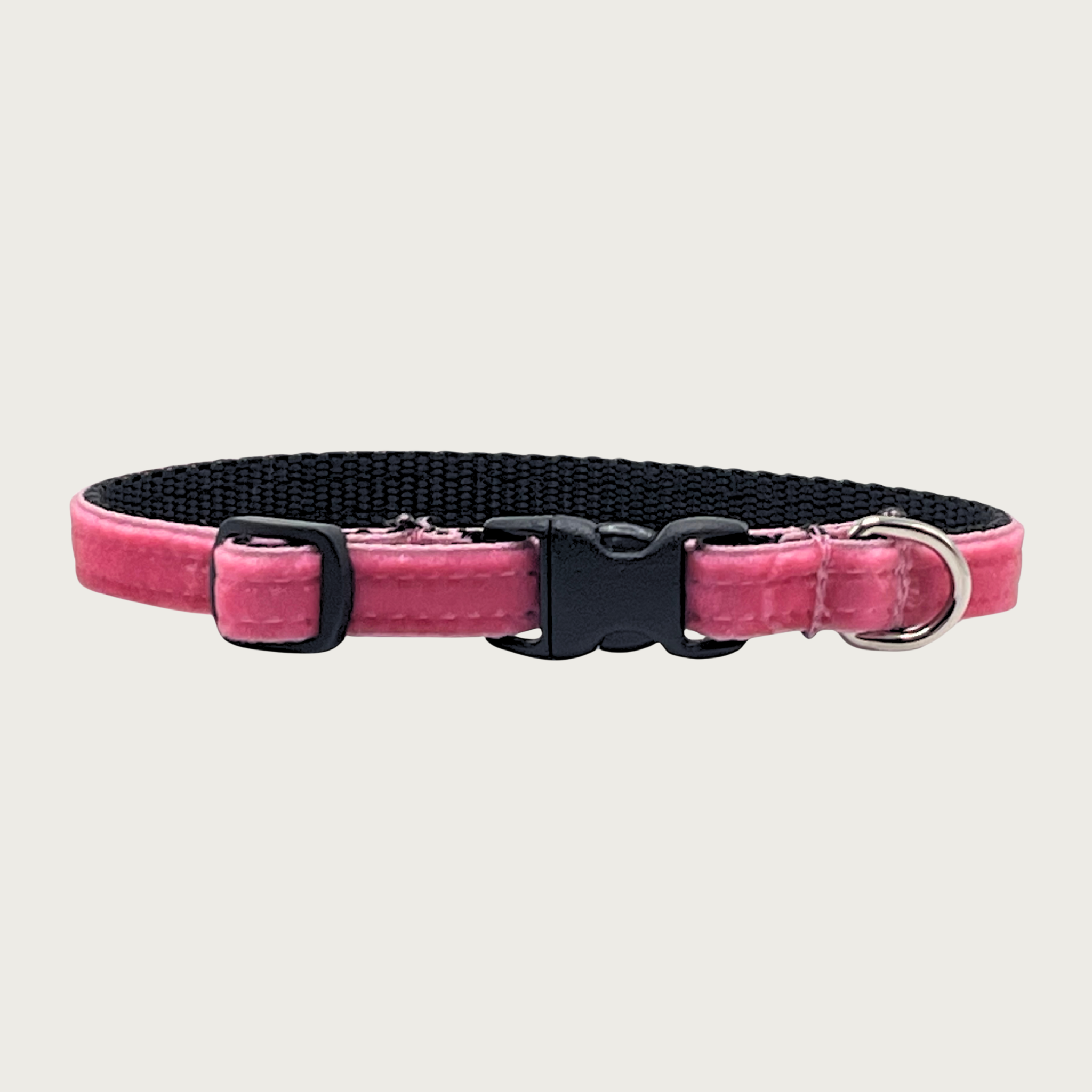 Skinny, medium-pink hued velvet teacup dog collar with a small D-ring, black nylon inner webbing and black plastic buckle.