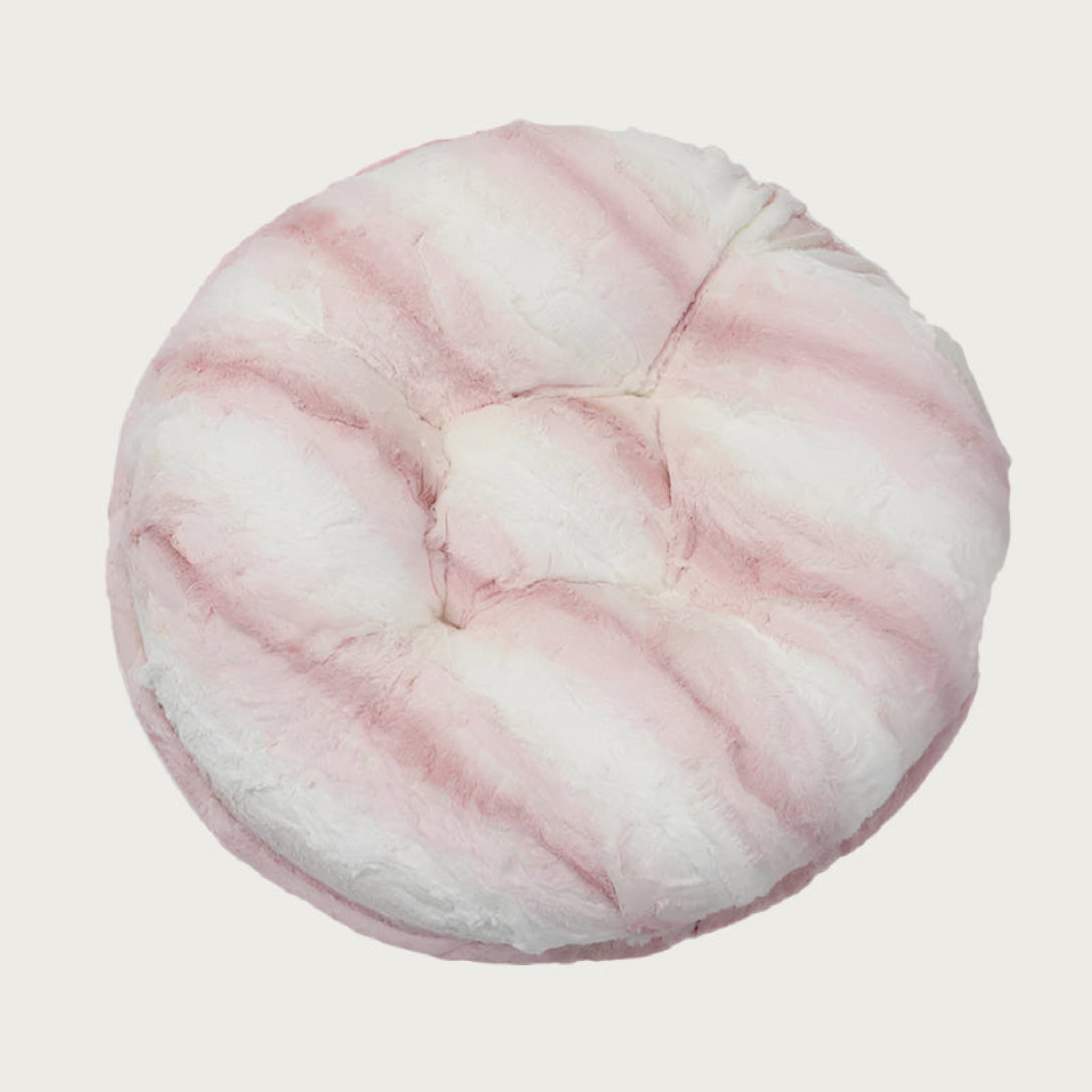 Round, plush pet bed made with faux fur in shades of pink and cream in a subtle striped pattern.