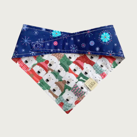 Dog bandana with deep blue & delicate multicolor snowflake pattern on top, and polar bears wearing hats, scarves & sweaters on the reverse.