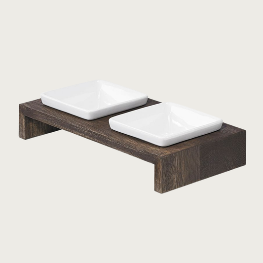 XS double bowl, elevated dog feeder. Stand is a rich dark brown wood, in a simple rectangular design. With 2 square white ceramic bowls.