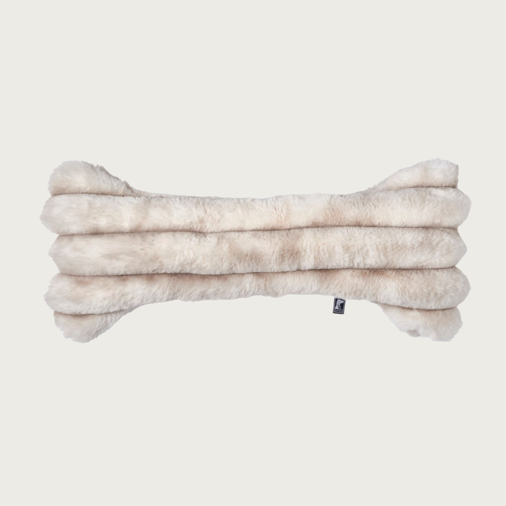 Bone-shaped plush dog pillow in muddled cream & beige tones. It features a horizontal ridged texture.