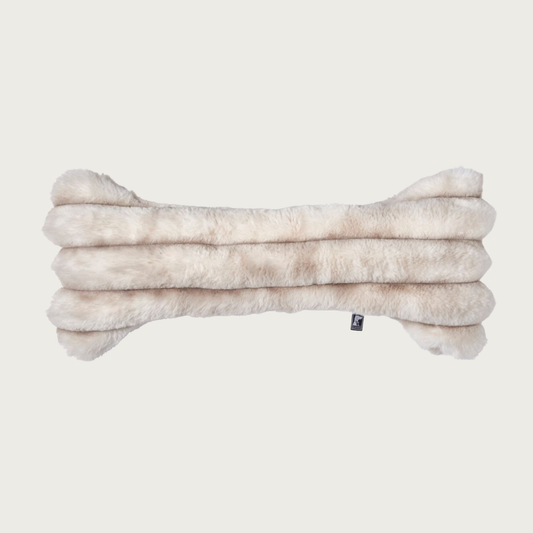 Bone-shaped plush dog pillow in muddled cream & beige tones. It features a horizontal ridged texture.