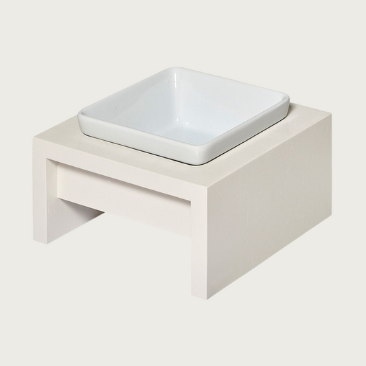 SM/MD Single bowl, elevated dog feeder. Stand is a creamy white color, in a simple square design. Square white ceramic bowl in center.