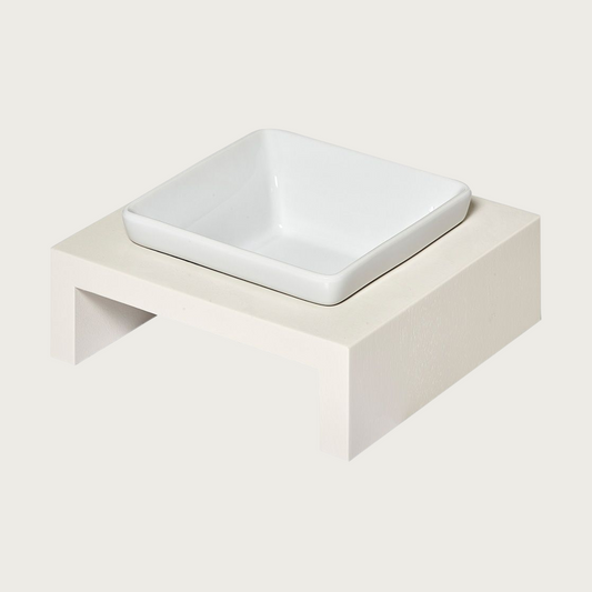 XS single bowl, elevated dog feeder. Stand is a creamy white color, in a simple square design. Square white ceramic bowl in center.