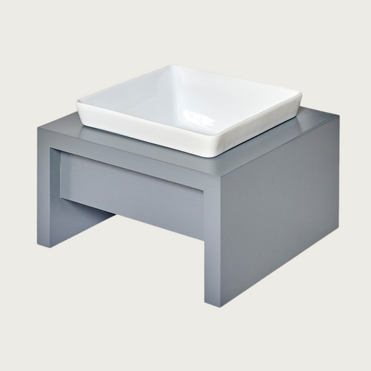 SM/MD Single bowl, elevated dog feeder. Stand is a medium grey color, in a simple square design. Square white ceramic bowl in center.