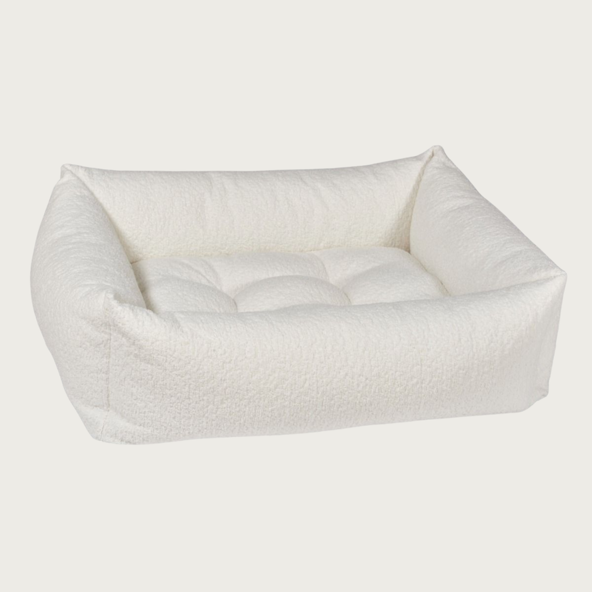 Cream colored, textured rectangular pet bed with bolsters & tufted center cushion.
