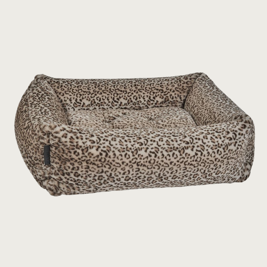 Faux fur plush rectangular pet bed with bolsters & tufted center cushion. It has a leopard print in shades of light & dark brown.