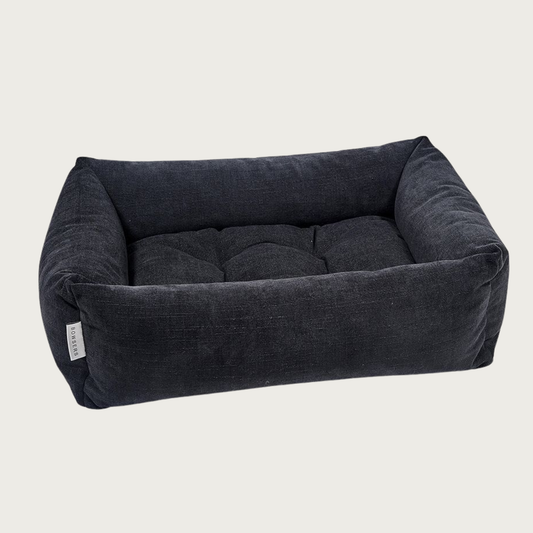 Licorice (black) colored, rectangular pet bed with bolsters & tufted center cushion. It has a slightly textured, stonewashed appearance.