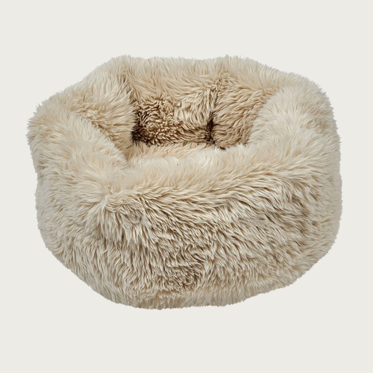 Plush, fluffy, nest-style pet bed with high sides, in light beige shaggy faux fur.