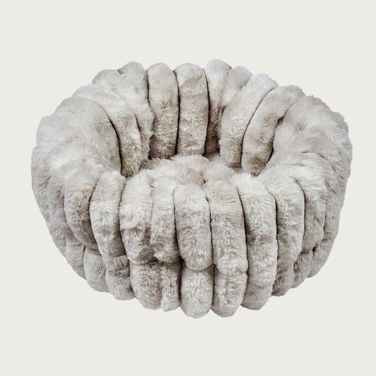 Plush, fluffy, nest-style pet bed with high sides, in muddled cream & light beige tones. It features a vertical ridged texture.
