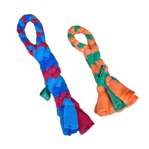 One of each size of Chelsy's Toys tug toy, side by side. These knotted, rope-style fleece toys have an integrated loop "handle", with a thicker knotted body, and loose fleece ends. Color examples are medium and dark blue with maroon for the X-Large toy, and green & orange for the small toy.