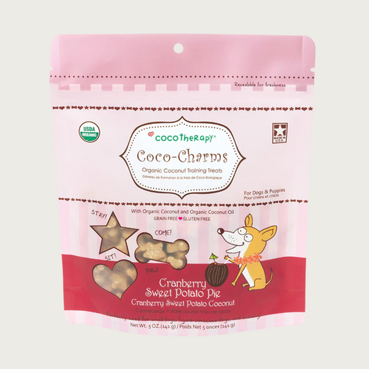 5 oz pink bag of CocoTherapy Coco-Charms Cranberry Sweet Potato Pie organic coconut training treats for dogs. Made with coconut & coconut oil. Grain-free, gluten free. USDA organic, made in USA. Treats visible through 3 clear windows are tiny (smaller than a dime) and tan colored, and in three shapes: hearts, stars and bones.