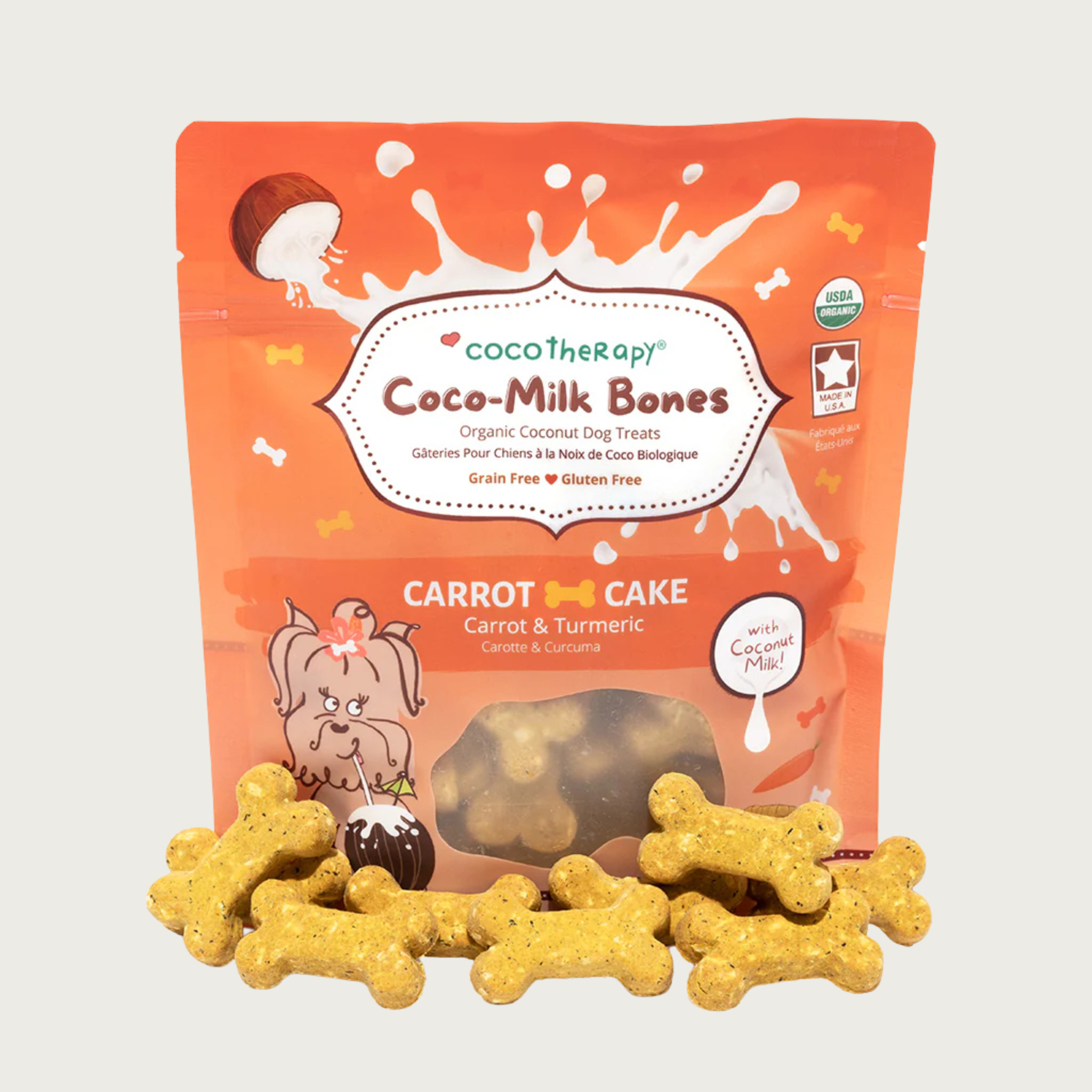 6 oz orange bag of CocoTherapy Coco-Milk Bones Carrot Cake dog treats with treats displayed in front. Made with carrot, turmeric & coconut milk. Grain-free, gluten free. USDA organic, made in USA. Treats in front of bag are orangish-tan in color and bone-shaped.