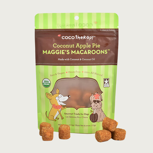 4 oz green and brown bag of CocoTherapy Coconut Apple Pie Maggie's Macaroons gourmet treats for dogs. Made with coconut & coconut oil. Raw & vegan, grain-free, 100% all natural. USDA organic, made in USA. Sample treats in front of bag are brown, and look like tater tots.