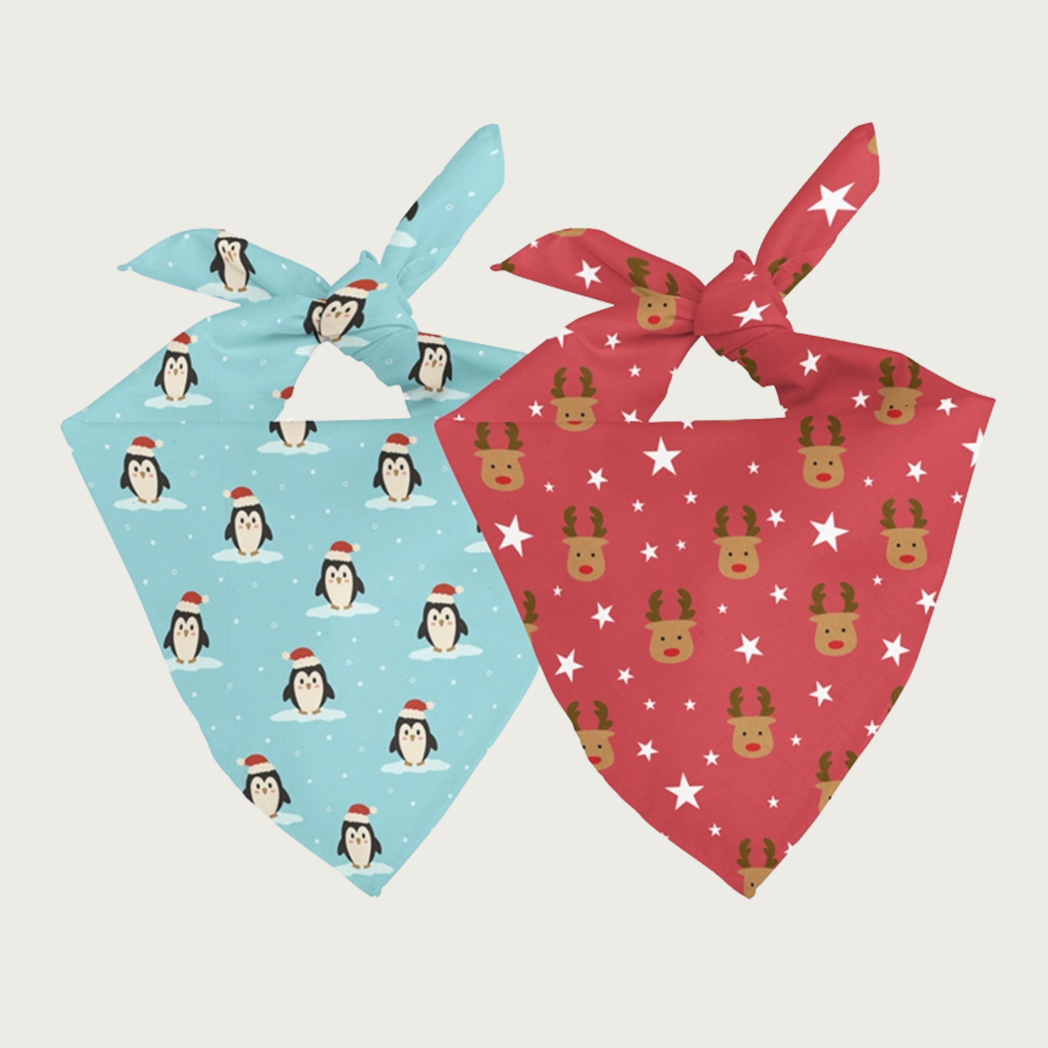 Two sides of the same dog bandana, shown side by side. One side has a light aqua blue with tiny white polka dot background, with penguins wearing Santa hats. The other side has a medium red with various sizes of white stars background, with simple brown reindeer with red noses.