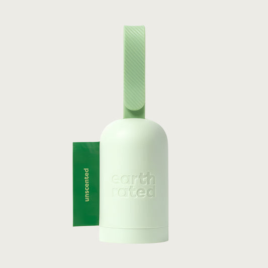 Light green, capsule-shaped poop bag holder with flat bottom, and adjustable leash strap.