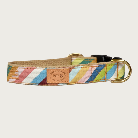 Dog collar with a colorful, diagonal striped pattern, in numerous shades of muted blues, greens, browns, pinks, and ivory. Has a tan cotton underside, brass hardware and black plastic buckle.