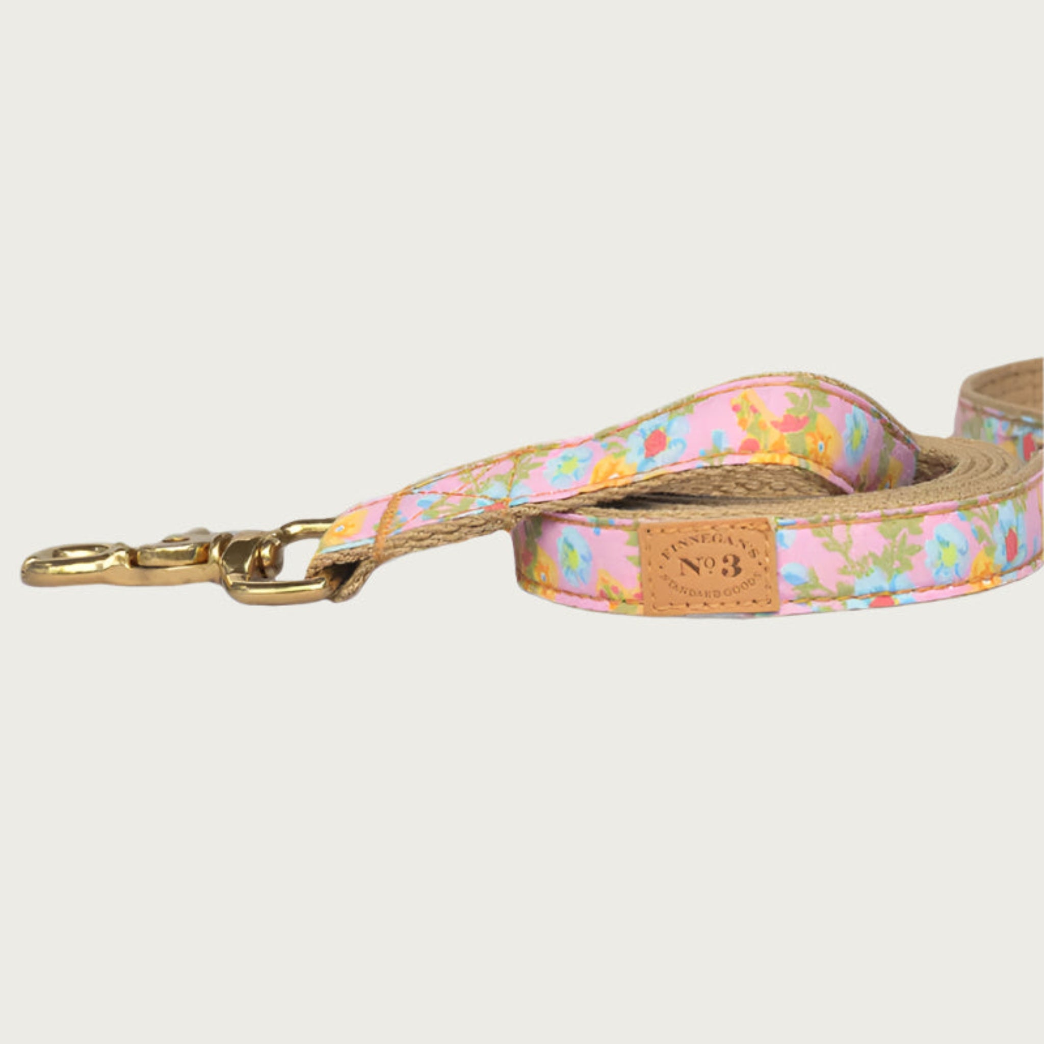 Pretty floral dog leash with a pink base color and flowers in light blue and yellow, with greenery. Brass clasp.