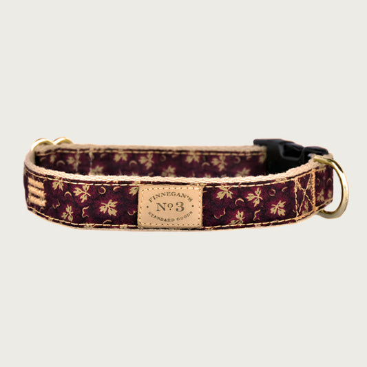 Dog collar with a deep burgundy colored background, with tan leaves accented with lighter shades of burgundy.