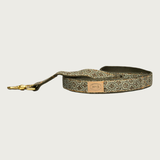 Dog leash in shades of olive green, with a brownish, floral medallion shaped pattern.