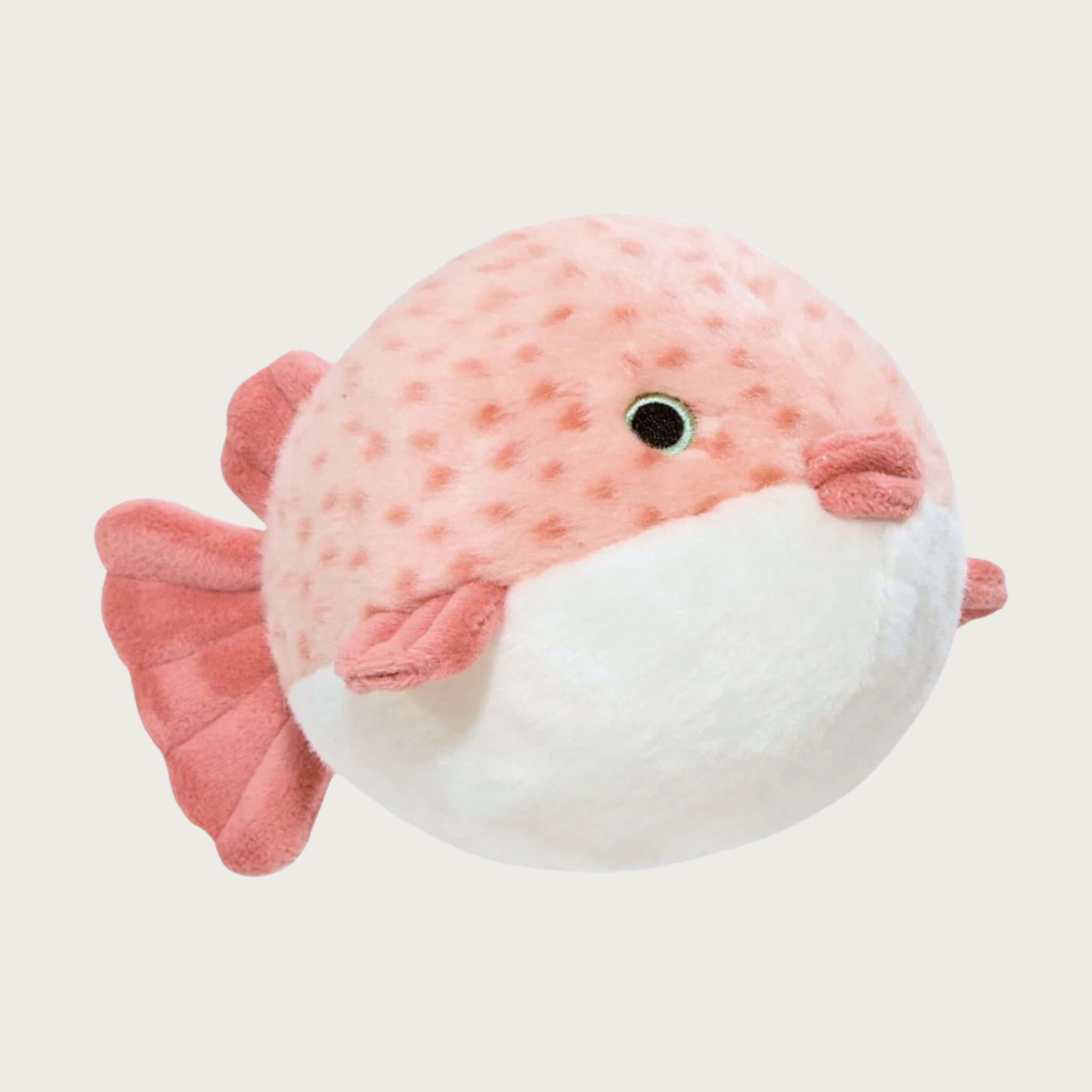 Plush dog toy resembling a round puffer fish with light salmon pink body with darker salmon colored spots, and fins & lips in darker salmon pink. It has a white underbelly and embroidered eyes. 