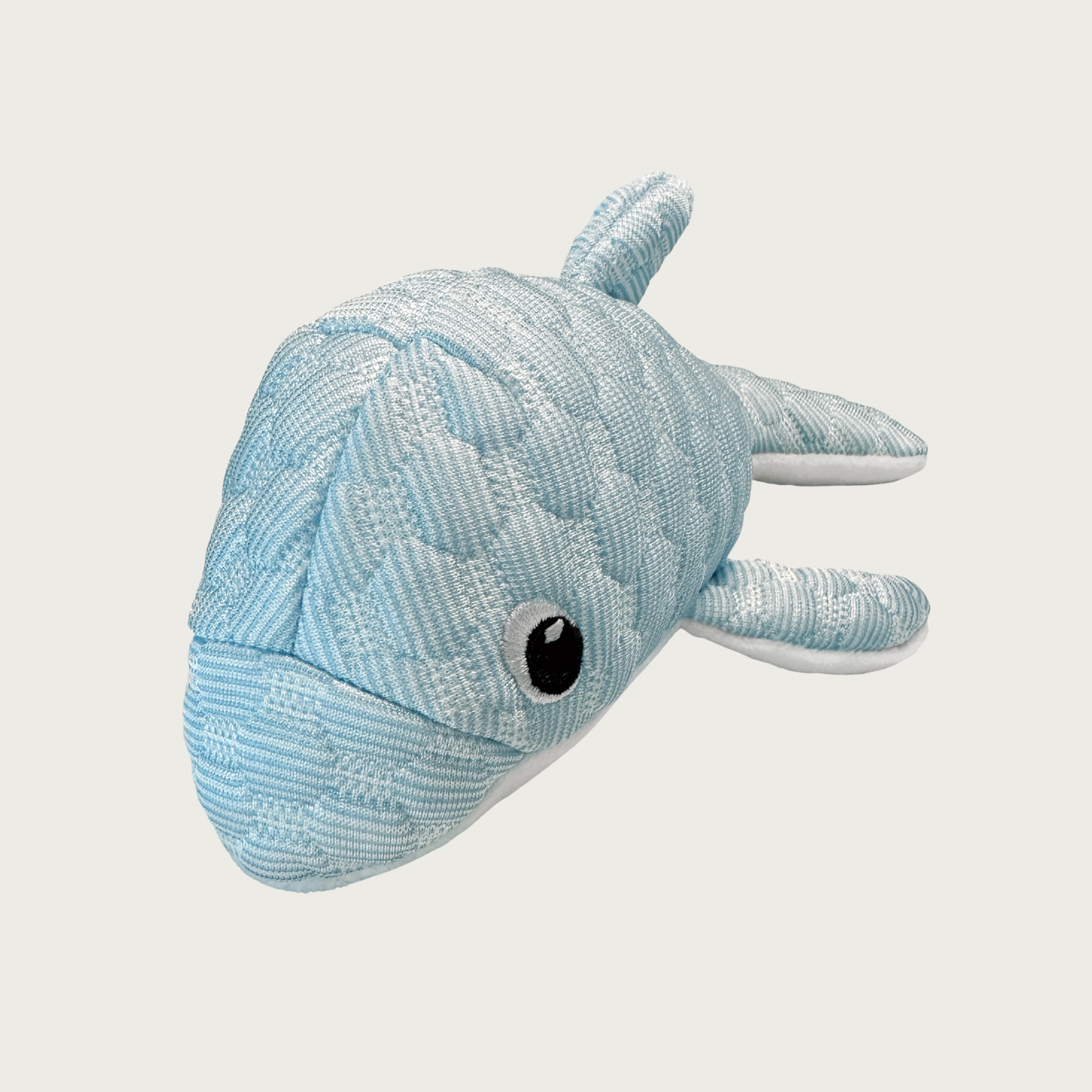 Head-on view of the Puff Plushies Dolphin dog toy. It is pale blue with a puffy, quilted texture, with embroidered eyes.