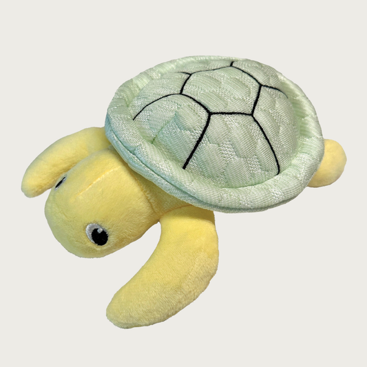 Dog toy shaped like a sea turtle, with a pale green quilted "shell" and pale yellow plush body, and embroidered eyes.