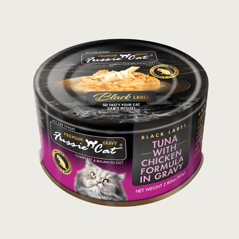 2.82 oz black & purple can of Fussie Cat Black Label Tuna with Chicken Formula in Gravy. Complete and balanced diet for all life stages. Fortified with vitamins and minerals. So tasty your cat can't resist! Small photo on top of can shows product inside - flakes and shreds of tuna and chicken in gravy.
