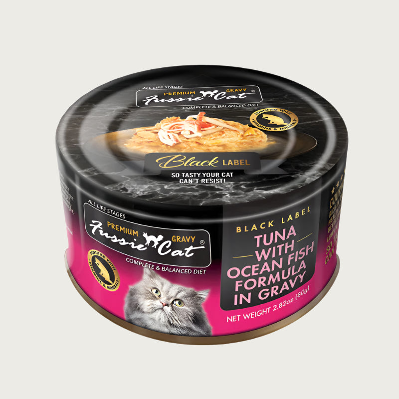 2.82 oz black & hot pink can of Fussie Cat Black Label Tuna with Ocean Fish Formula in Gravy. Complete and balanced diet for all life stages. Fortified with vitamins and minerals. So tasty your cat can't resist! Small photo on top of can shows product inside - flakes and shreds of tuna and ocean fish in gravy.