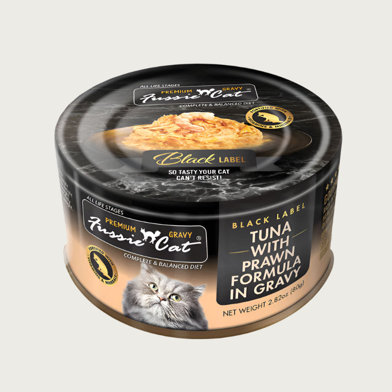 2.82 oz black & tan can of Fussie Cat Black Label Tuna with Prawn Formula in Gravy. Complete and balanced diet for all life stages. Fortified with vitamins and minerals. So tasty your cat can't resist! Small photo on top of can shows product inside - flakes of tuna and small, whole prawn in gravy.