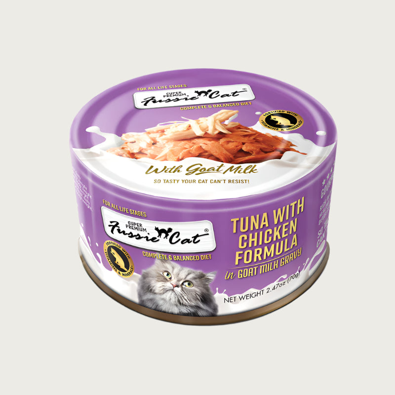A 2.47 oz purple can of Fussie Cat Tuna with Chicken Formula in Goat Milk Gravy cat food. Super premium, for all life stages - "so tasty your cat can't resist!" Image on top of can shows shredded tuna and chicken.