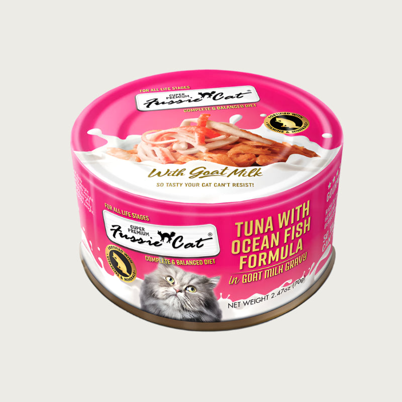 A 2.47 oz hot pink can of Fussie Cat Tuna with Ocean Fish Formula in Goat Milk Gravy cat food. Super premium, for all life stages - "so tasty your cat can't resist!" Image on top of can shows flaked tuna and shredded fish.
