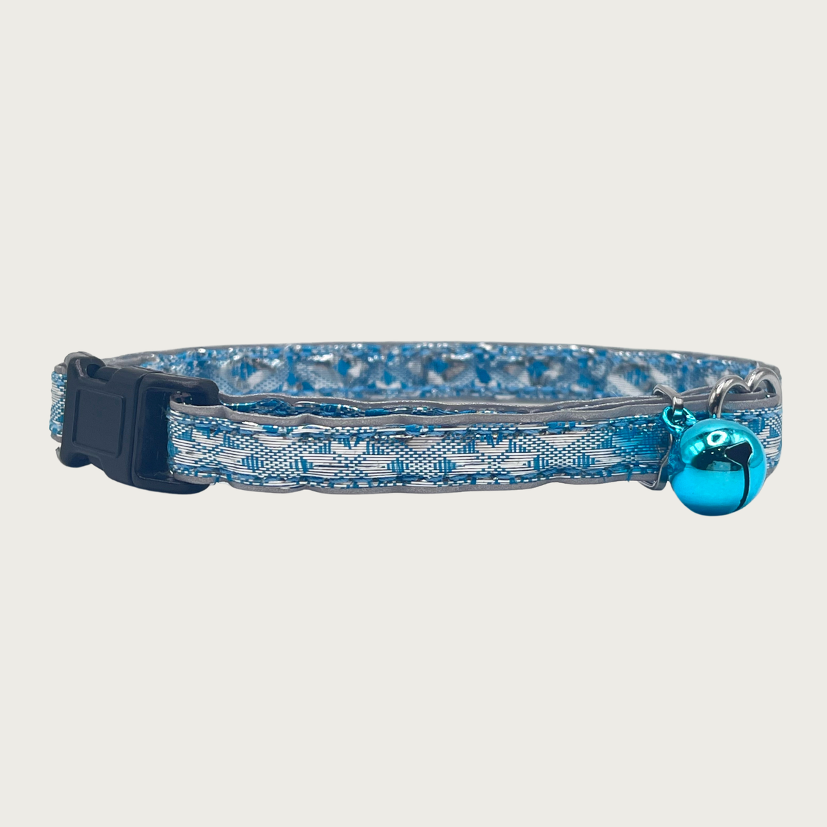 A turquoise blue and silver, geometric patterned cat collar with a small turquoise blue bell and black buckle.
