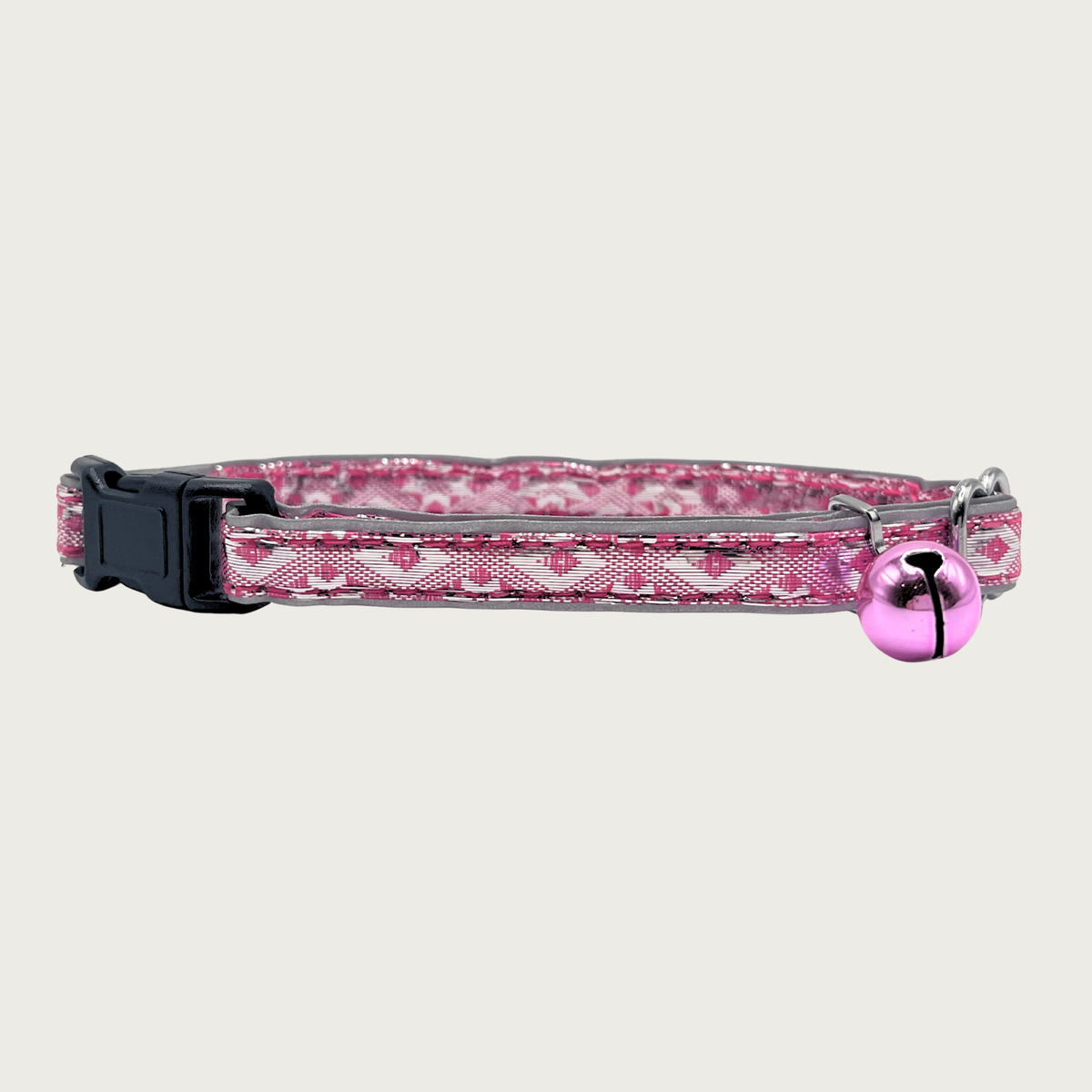 A bubblegum pink and silver, geometric patterned cat collar with a small bubblegum pink bell and black buckle.