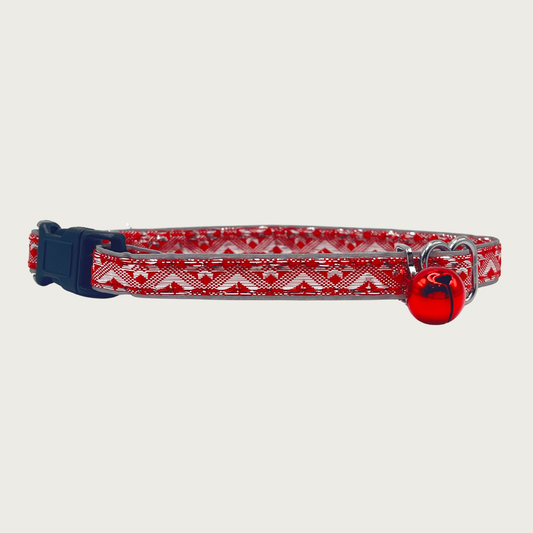A red and silver, geometric patterned cat collar with a small red bell and black buckle.