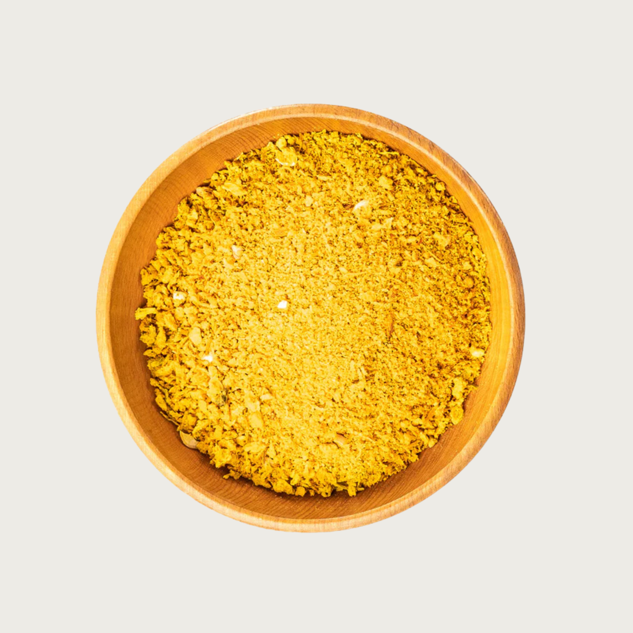 Wooden bowl filled with freeze dried Golden Blend-coarsely chopped, orange-yellow veggie flakes.