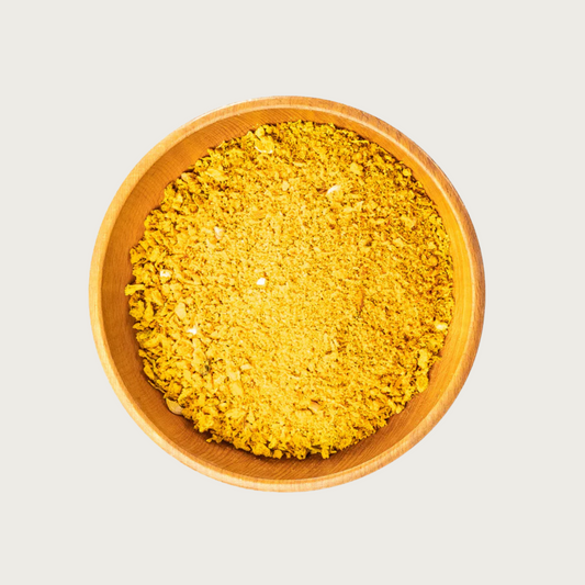 Wooden bowl filled with freeze dried Golden Blend-coarsely chopped, orange-yellow veggie flakes.