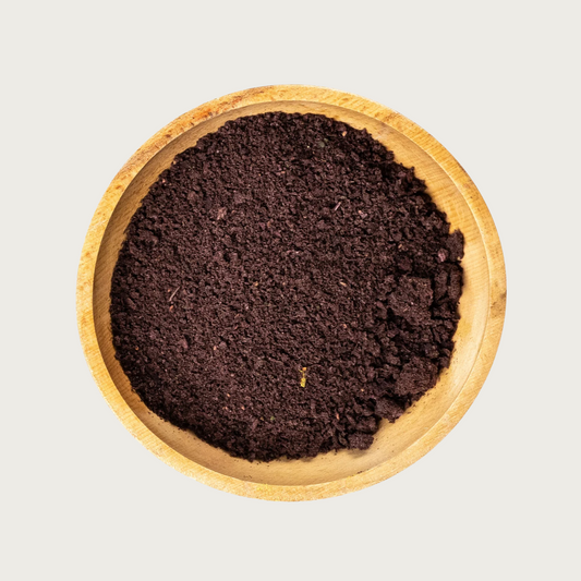 Wooden bowl filled with freeze dried Vitality Blend-finely chopped, deep brownish-purple veggie flakes.