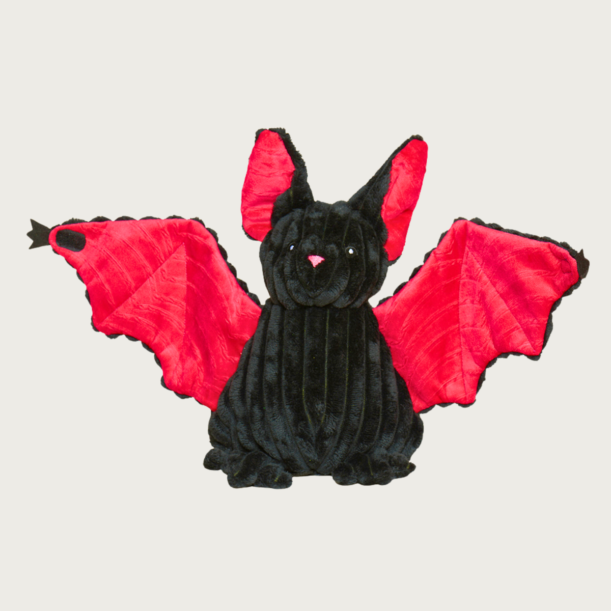 Plush bat shaped dog toy with wings extended. It has a black, wide wale corduroy head & body, with bright red inner wings and inner ears. Simple embroidered facial details.