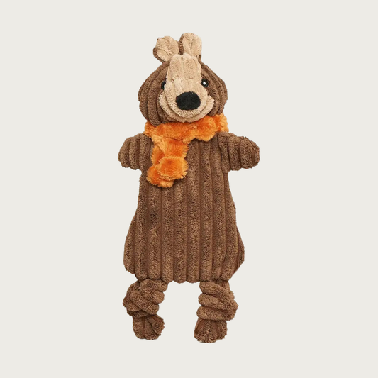 Small size of the Nutmeg Squirrel plush dog toy. Its flat body is made from brown wide wale corduroy, with beige accent on its face (with embroidered eyes & nose), and knots on its knees. It has a fuzzy orange scarf around its neck.
