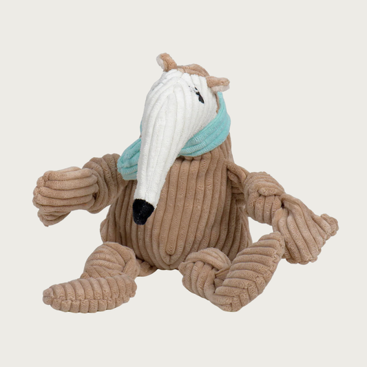 Corduroy dog toy shaped like an anteater. Its body and arms are tan colored, while its face/snout is white. It has black embroidered eyes with eyelashes, and it's also wearing a seafoam green scarf. Size Small.
