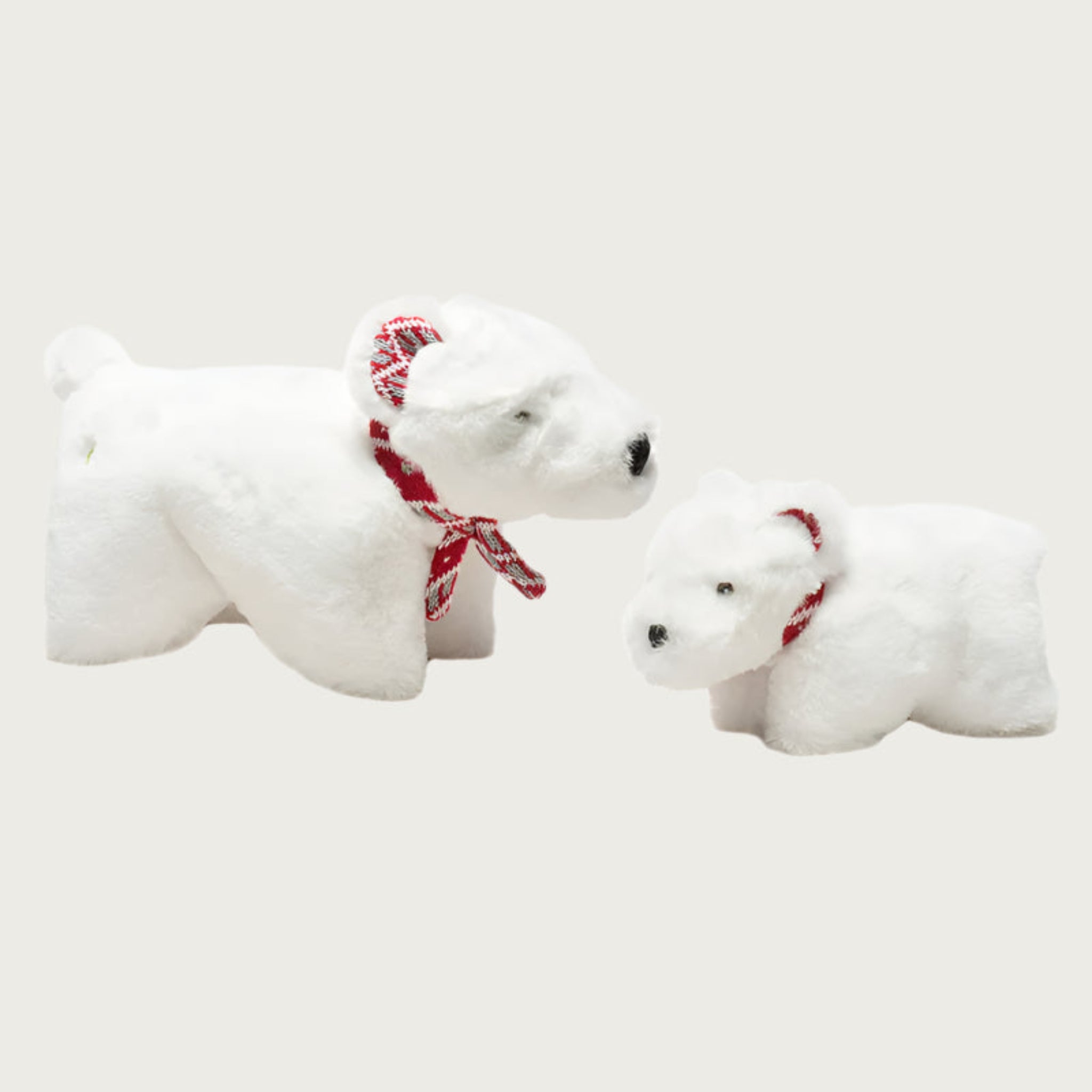 Small and large Squooshie Polar Bear dog toys sitting side by side to show size difference.