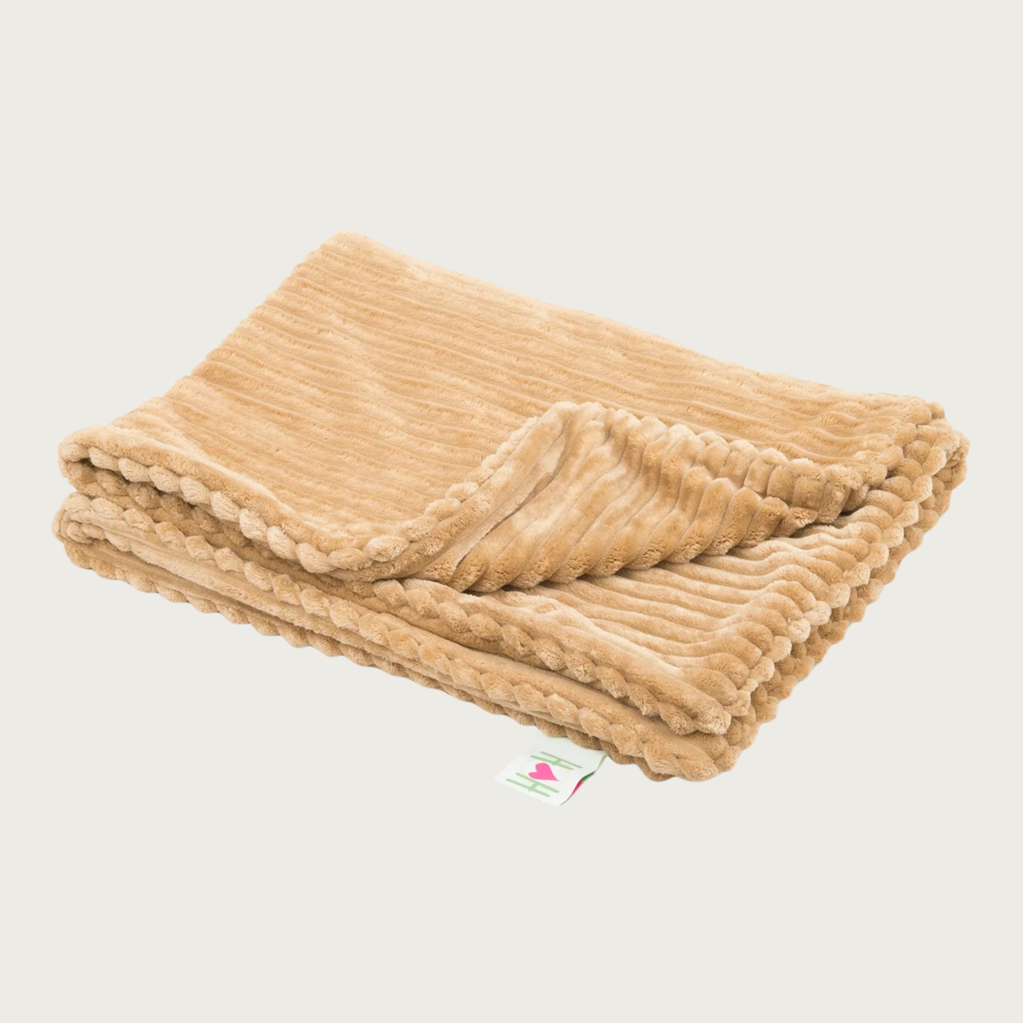 Folded wide-wale plush corduroy tan blanket with one corner folded back, and a Hugglehounds brand tag on the end.